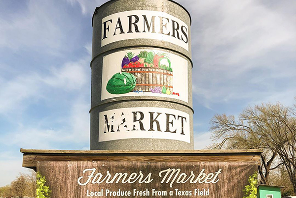 Barrel with Farmers Market branding on top of shed