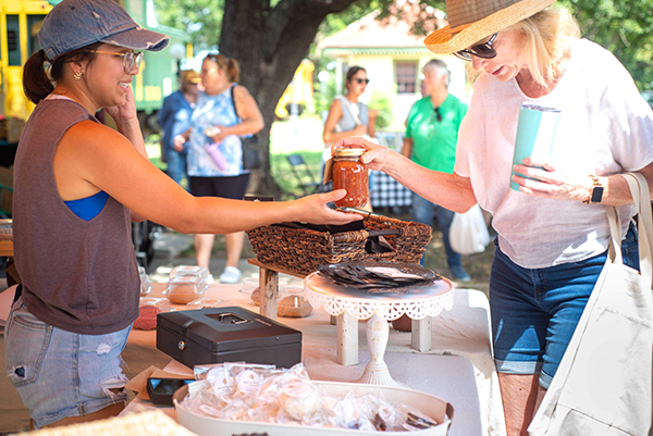 woman purchasing canned goods at farmers market